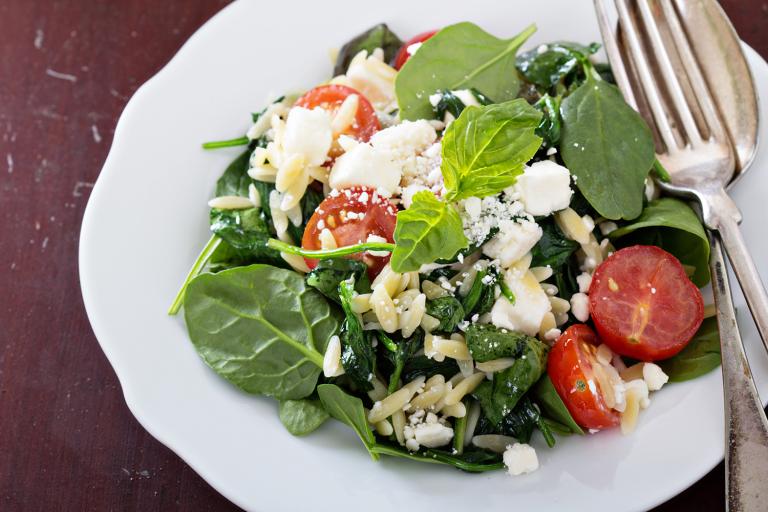 a plate of spinach with crumbled feta